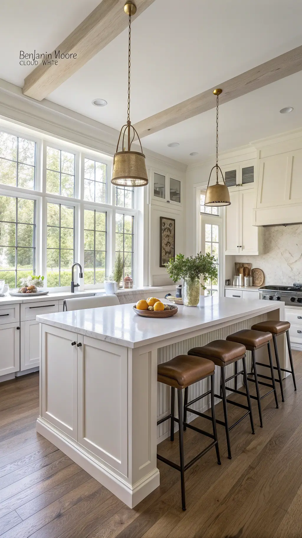 Bright, airy modern off-white kitchen with marble island, brass pendant lights, and morning sunlight streaming through sheer curtains.