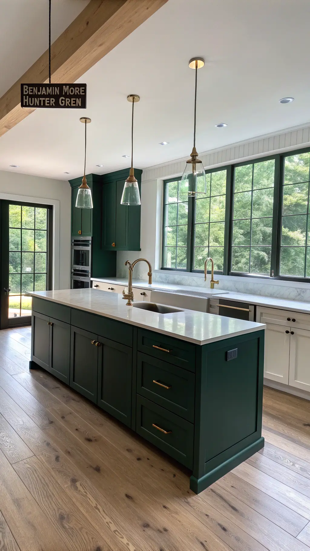 Modern minimalist kitchen with forest green cabinets, white quartz countertops, brass accents, and morning light streaming through floor-to-ceiling windows.