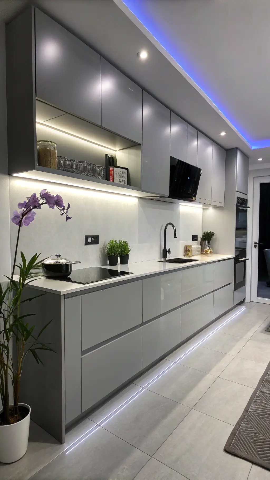 Urban minimal kitchen at night with glossy grey IKEA cabinets, LED lighting, floating shelves, black accessories, a purple orchid, and geometric decor.