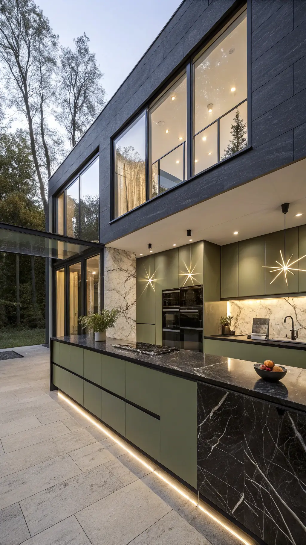 Modern kitchen with olive green handleless cabinets, black marble waterfall island, and double-height windows under dusk lighting.